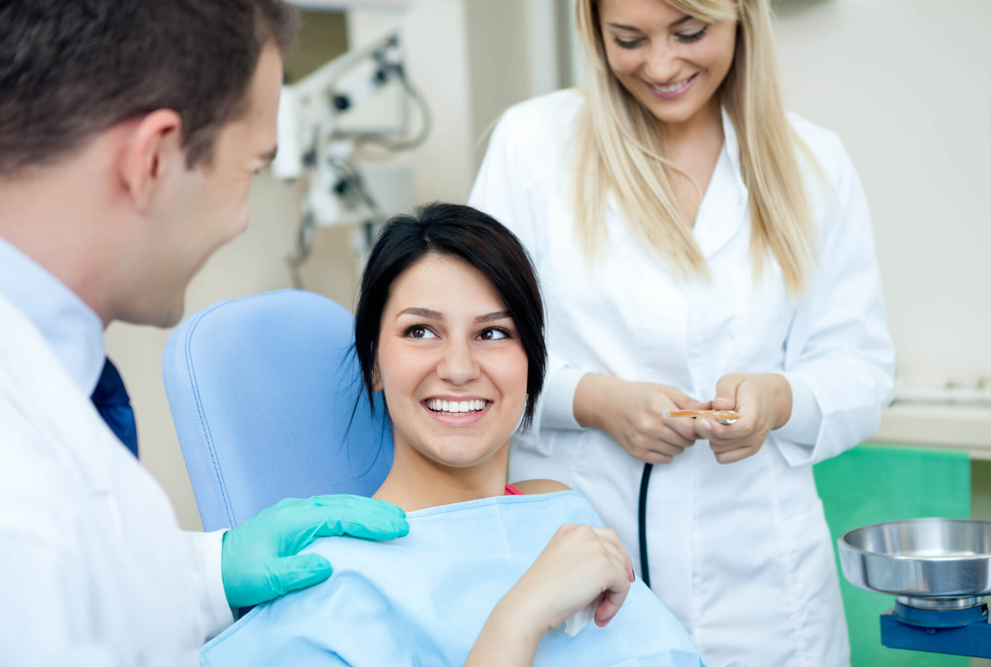 Smiling patient with dentists of a dental practice that got IT solutions