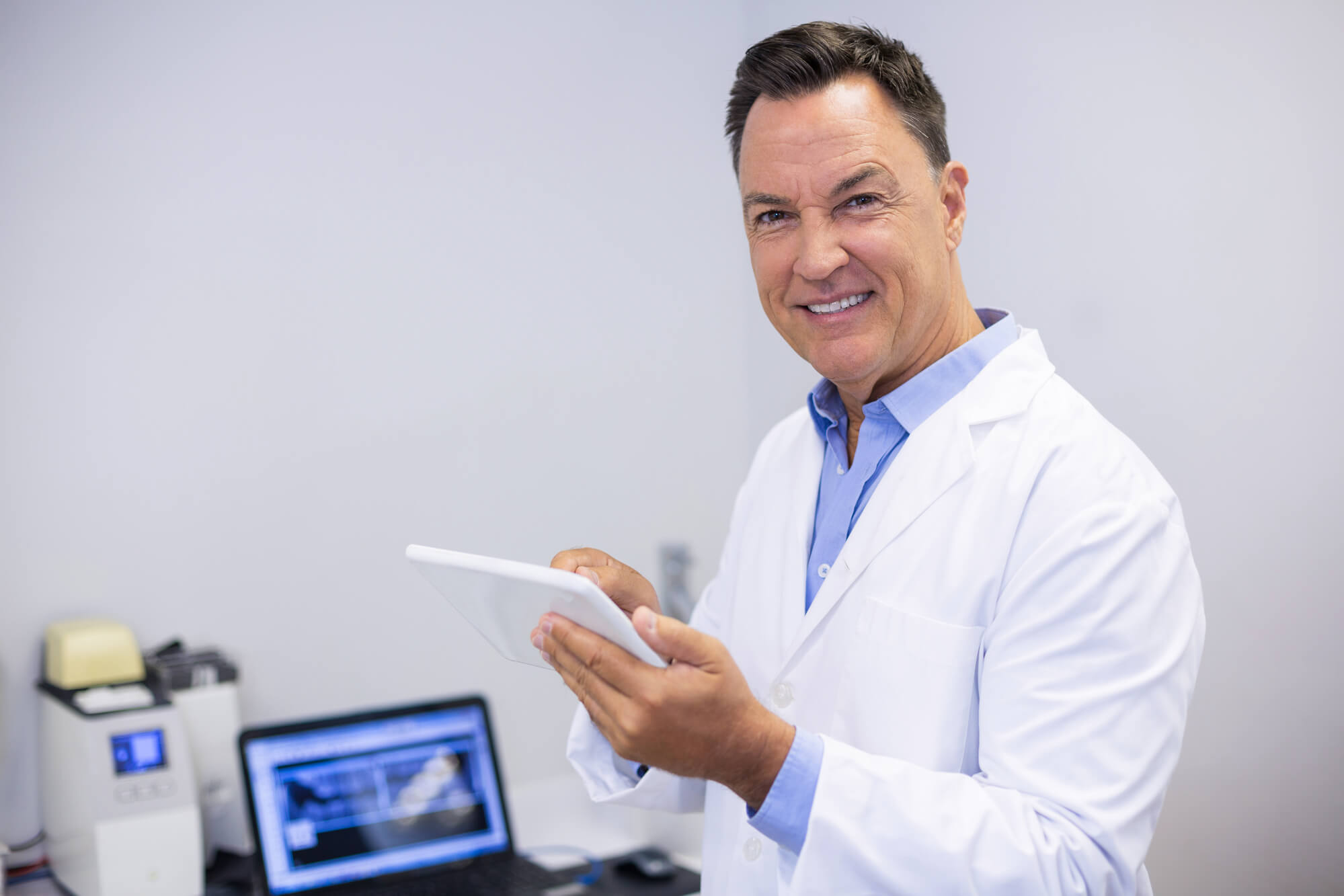 Smiling dentist at his practice after getting dental IT solutions