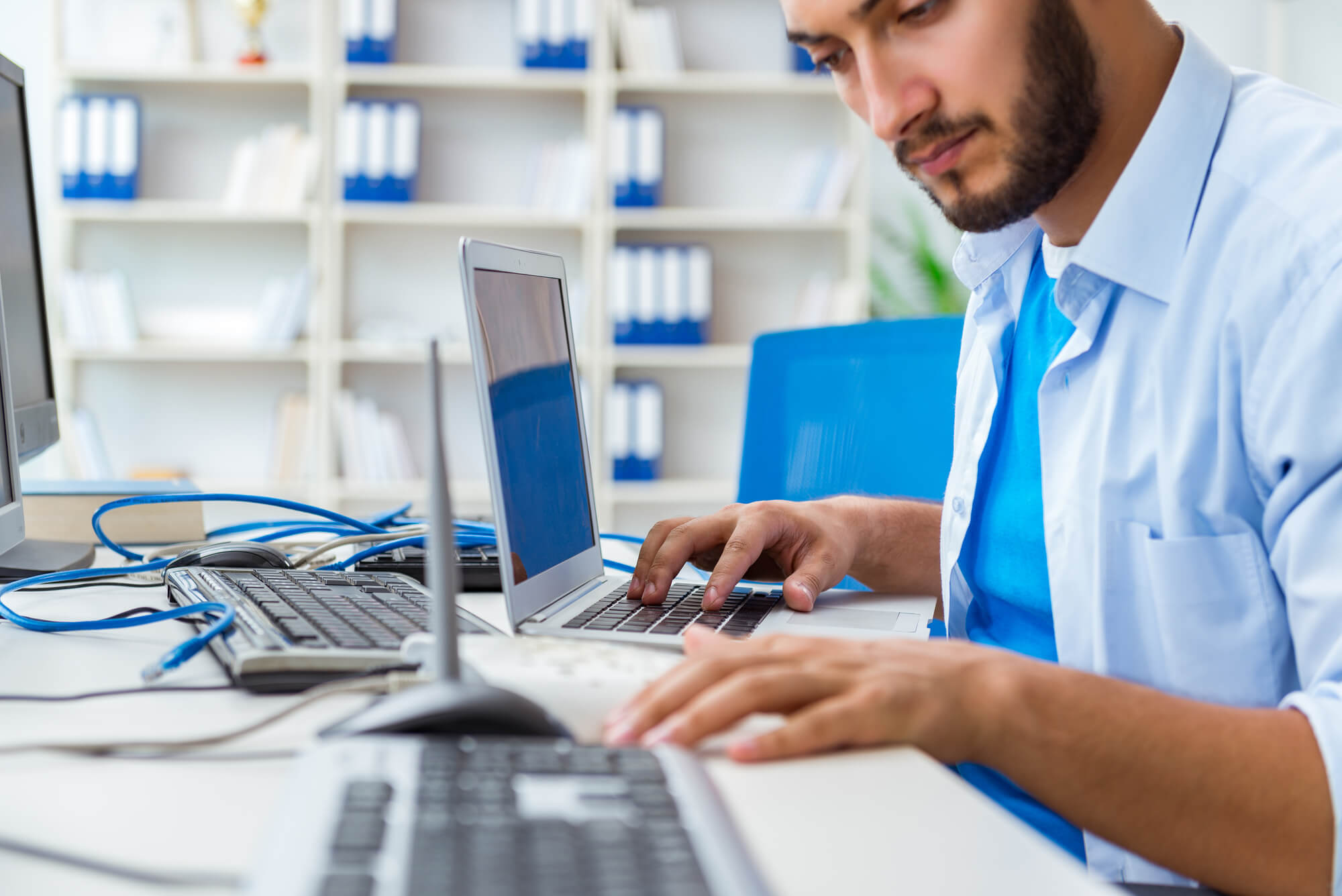 A Virtual CIO typing on a laptop during his work in it services in miami